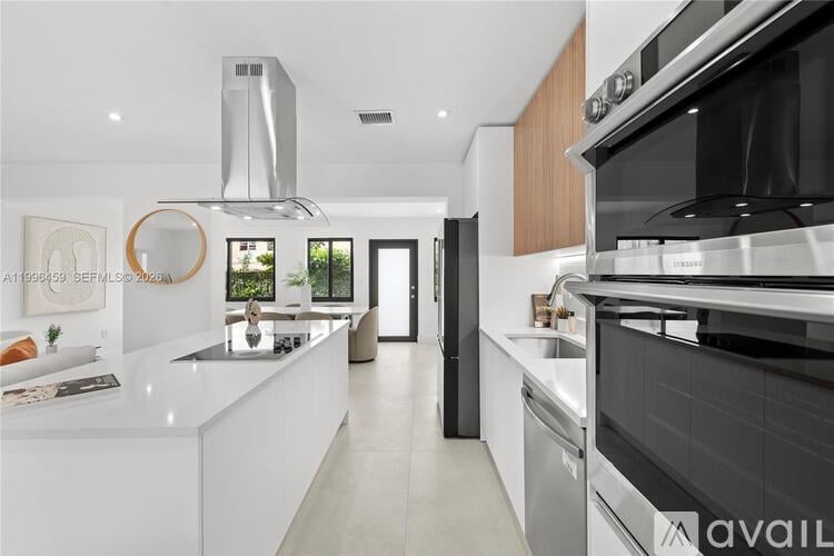 A modern kitchen with a stainless steel oven and a white countertop.