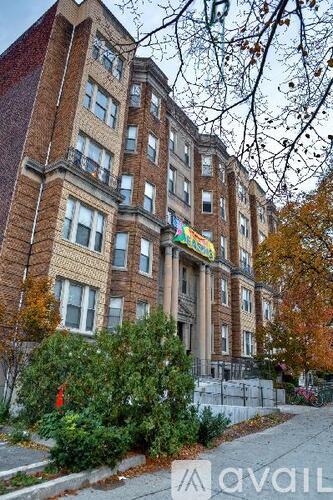 A tall brick building with a balcony on the top floor.