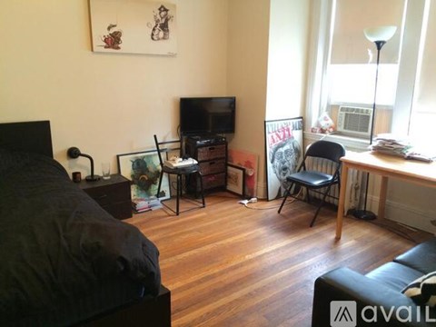 A living room with a black couch and a television.