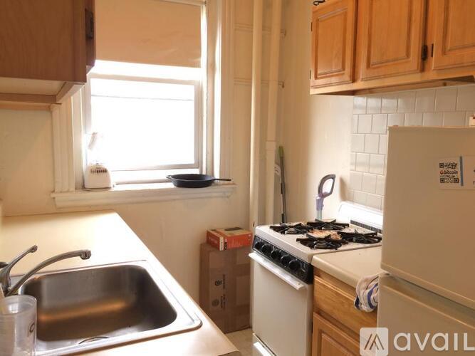 A kitchen with a stove, sink, and cabinets.
