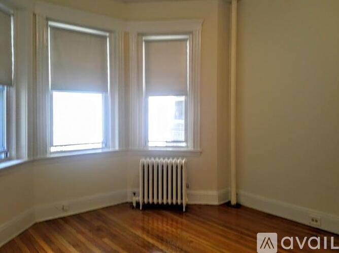 A room with a white radiator and wooden floors.