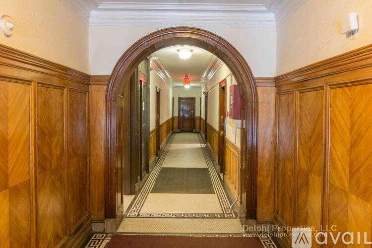 A hallway with wooden doors and a tiled floor.