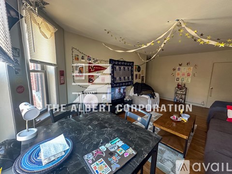 A living room with a black table and a sign that says "The Albert Corporation".