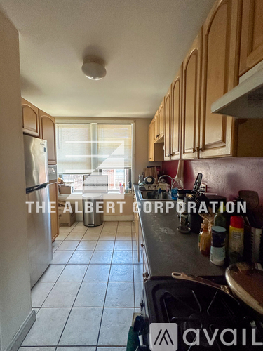 A kitchen with wooden cabinets and a refrigerator.