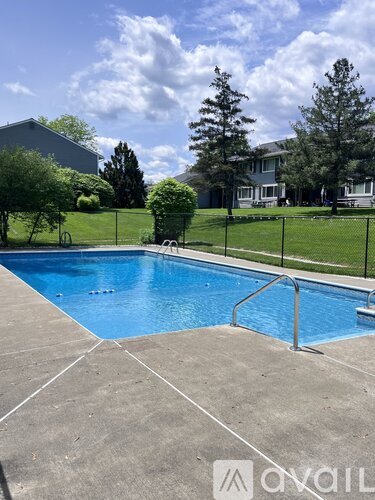 A swimming pool surrounded by a fence and trees.