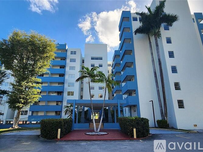 A modern building with blue and white balconies and a red entrance.
