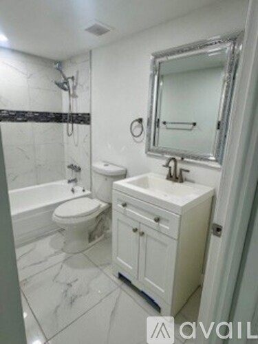 A bathroom with a toilet, sink, and mirror.