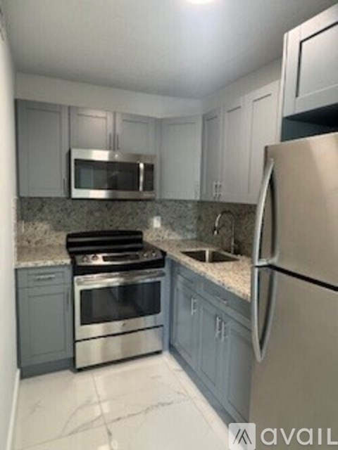 A kitchen with a stove, oven, microwave, and refrigerator.