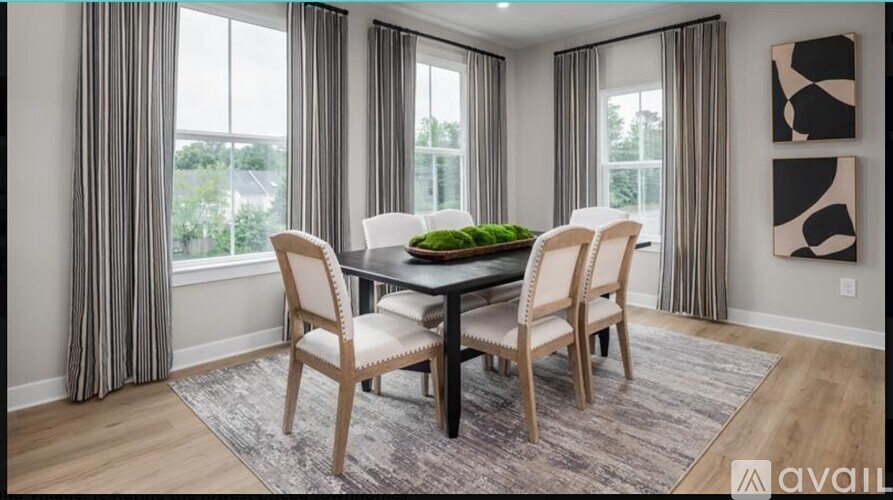 A dining room with a table and chairs.