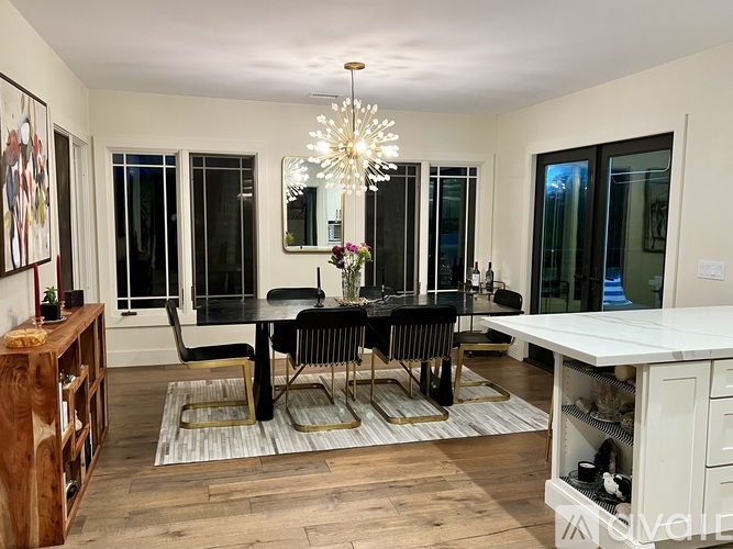 A dining room with a black table and chairs.