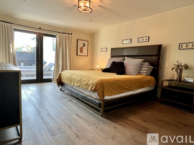 A bedroom with a large bed and a sliding glass door.