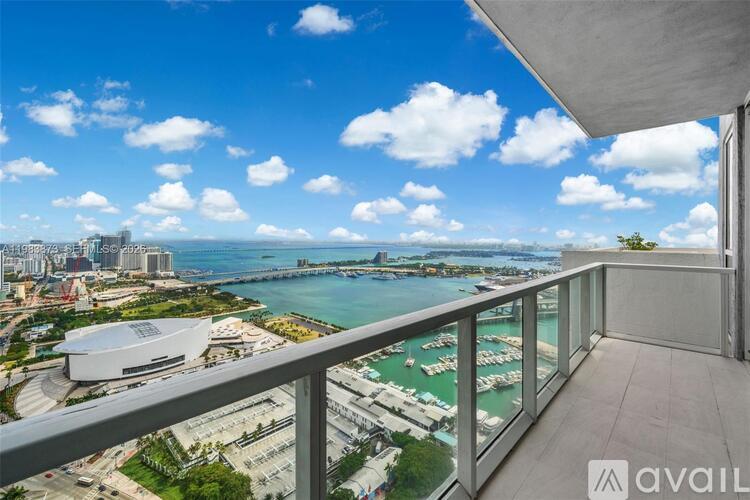 A balcony overlooks a cityscape with a body of water and boats.