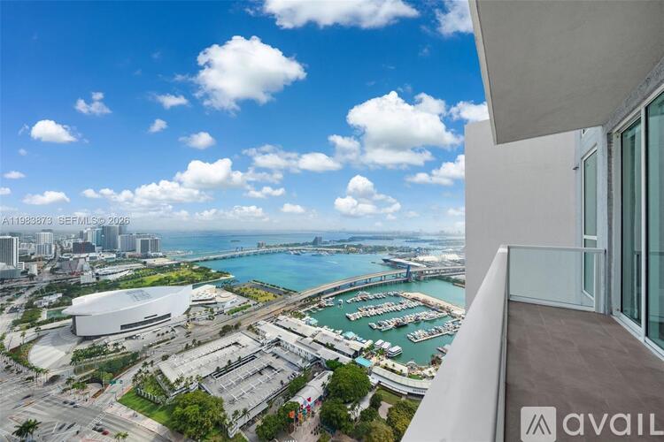 A view from a high-rise building overlooking a marina and a cityscape.