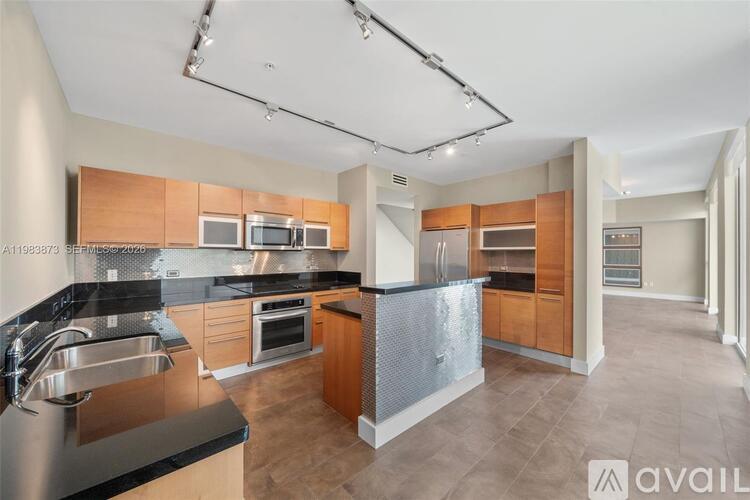 A modern kitchen with wooden cabinets and a black countertop.