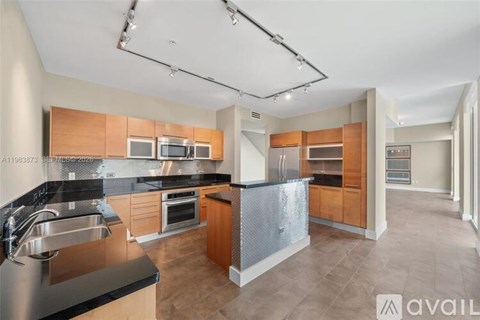 A modern kitchen with wooden cabinets and a black countertop.