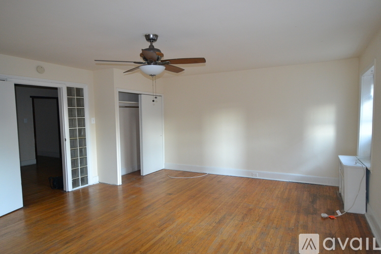 A room with a ceiling fan and wooden floors.