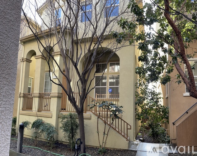 A beige building with a tree in front of it.