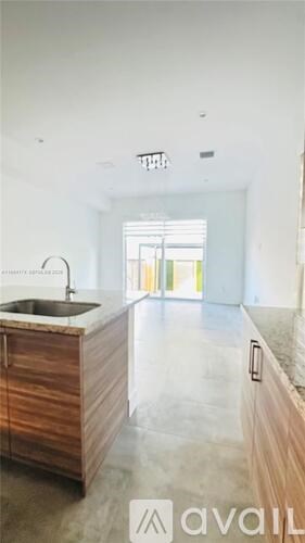 A kitchen with a sink and wooden cabinets.