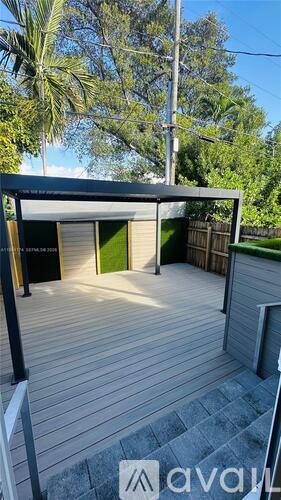 A wooden deck with a pergola and a green door.