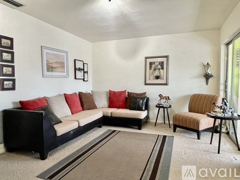 A living room with a black sofa and a striped armchair.
