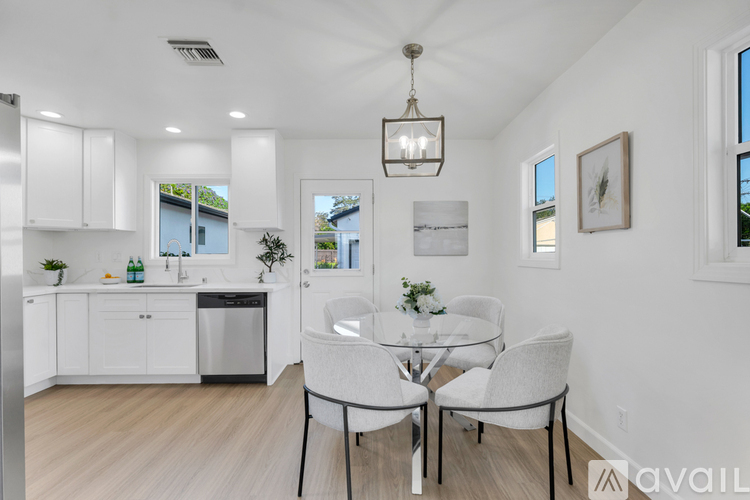 A modern kitchen with a dining table set for two.