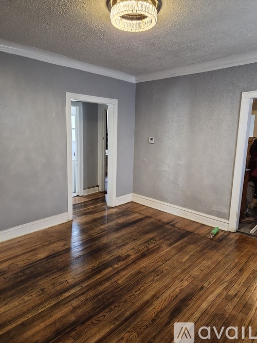 A room with wooden flooring and a light on the ceiling.