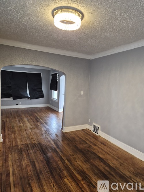 A room with wooden flooring and a light on the ceiling.