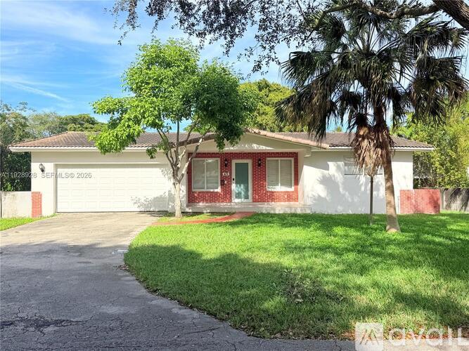 A house with a red door and a tree in front.