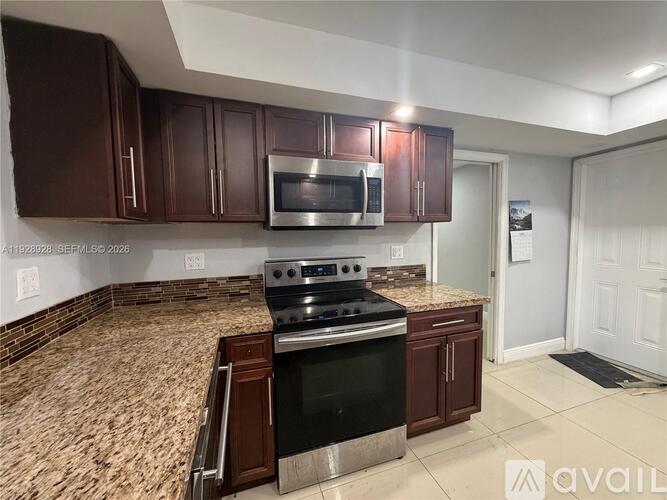A kitchen with brown cabinets and a black stove top oven.
