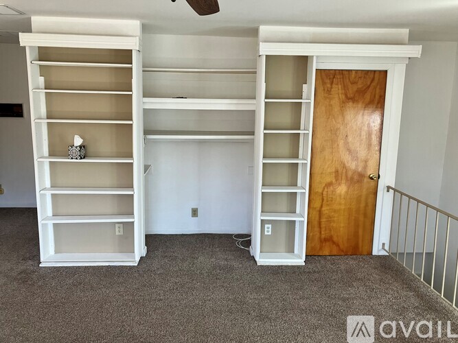 A room with a white bunk bed and a wooden door.