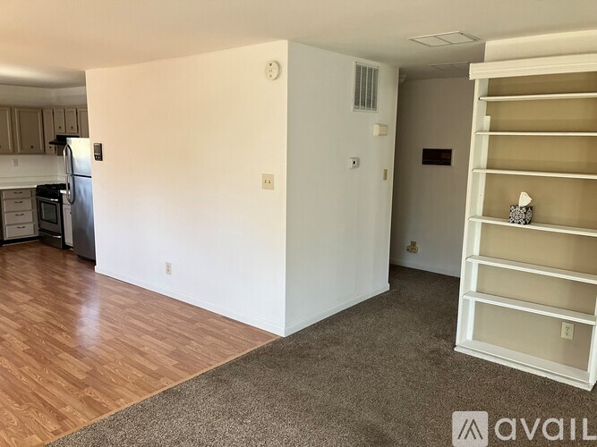 A room with a white wall and a brown carpet.