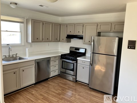 A kitchen with wooden floors and stainless steel appliances.
