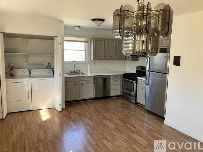 A kitchen with a refrigerator, oven, and sink.
