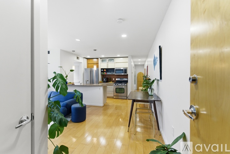 A modern kitchen with a blue chair and a wooden table.