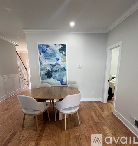 A dining room with a wooden table and chairs.