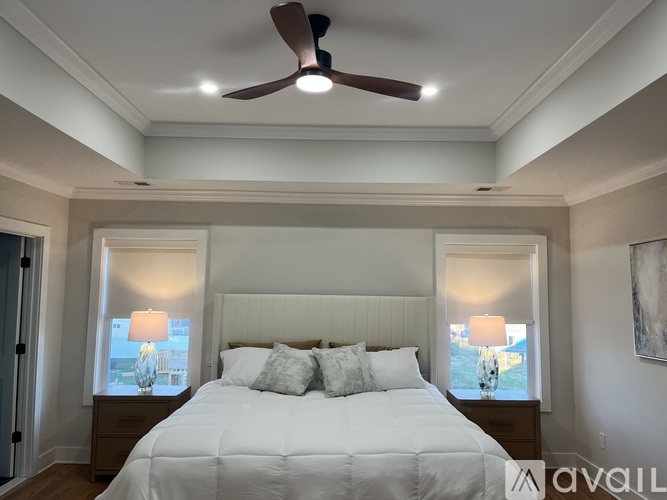 A bedroom with a large bed and a ceiling fan.