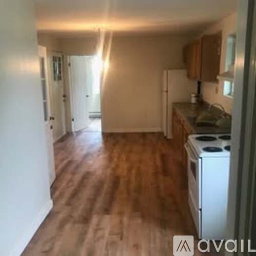 A kitchen with wooden floors and white appliances.