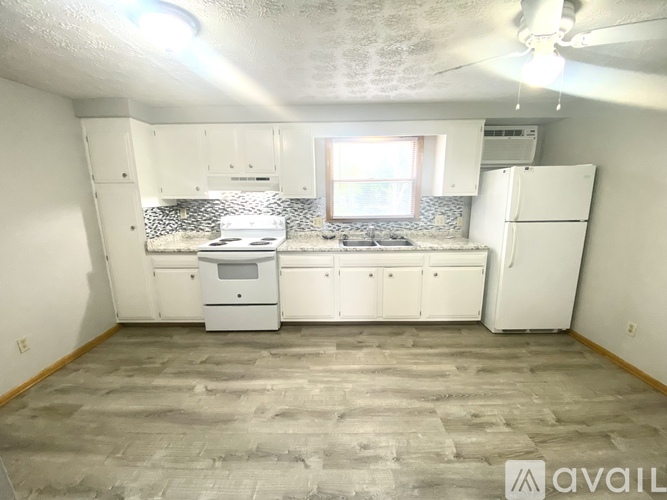 A kitchen with white appliances and cabinets is available for rent.