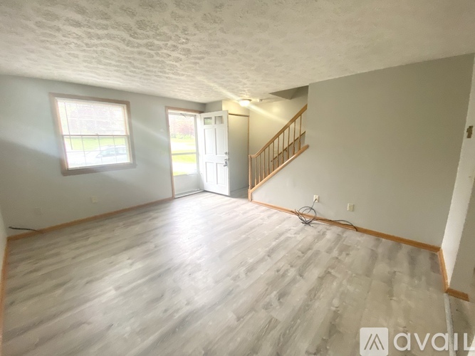 A room with wooden flooring and a window with blinds.