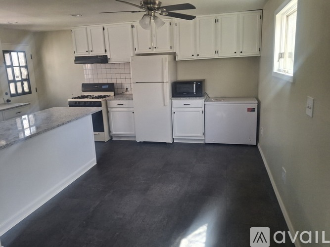 A kitchen with white appliances and cabinets.