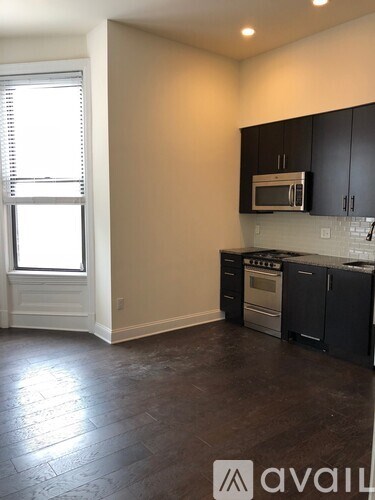 A kitchen with black cabinets and a microwave above the stove.