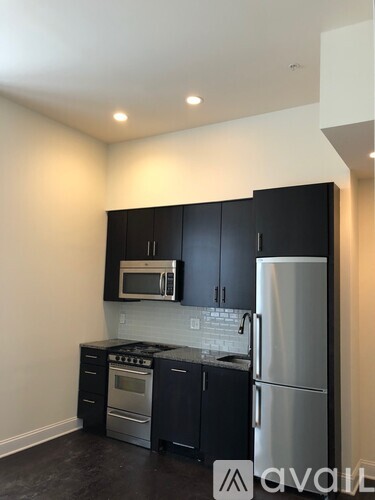 A kitchen with black cabinets and stainless steel appliances.