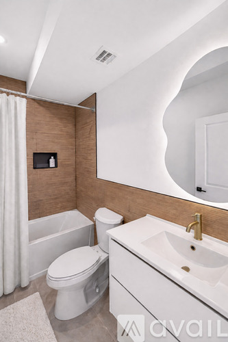 A bathroom with a toilet, sink, and mirror.
