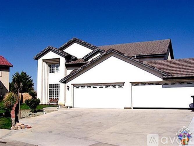 A white house with a red roof and a garage door.