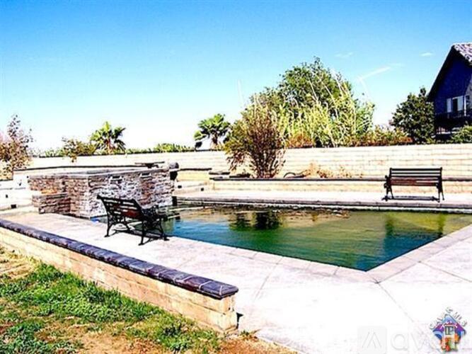 A pool with a bench and a wall next to it.