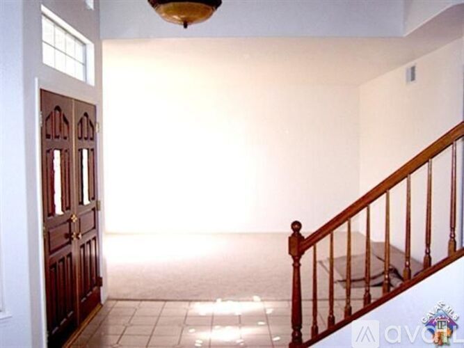A room with a wooden staircase and a chandelier.