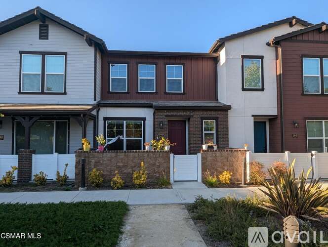 A house with a white fence and a brown front door.