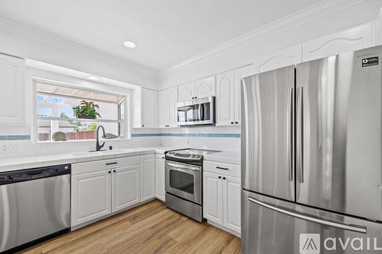 A kitchen with white cabinets and stainless steel appliances.
