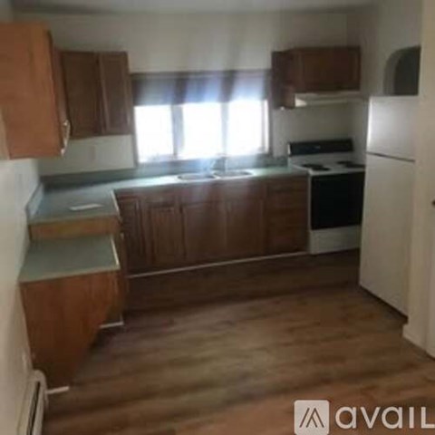 A kitchen with wooden cabinets and a white fridge.