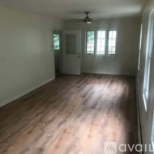 A room with wooden flooring and a ceiling fan.